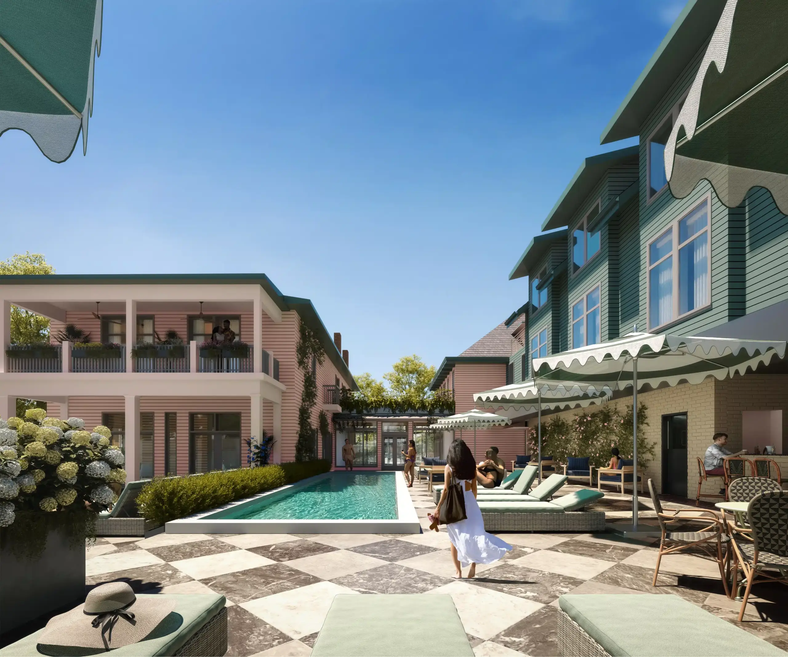 Swimming pool with buildings at both sides while people are relaxing. Two buildings are painted pink and teal and are joined by a corridor.