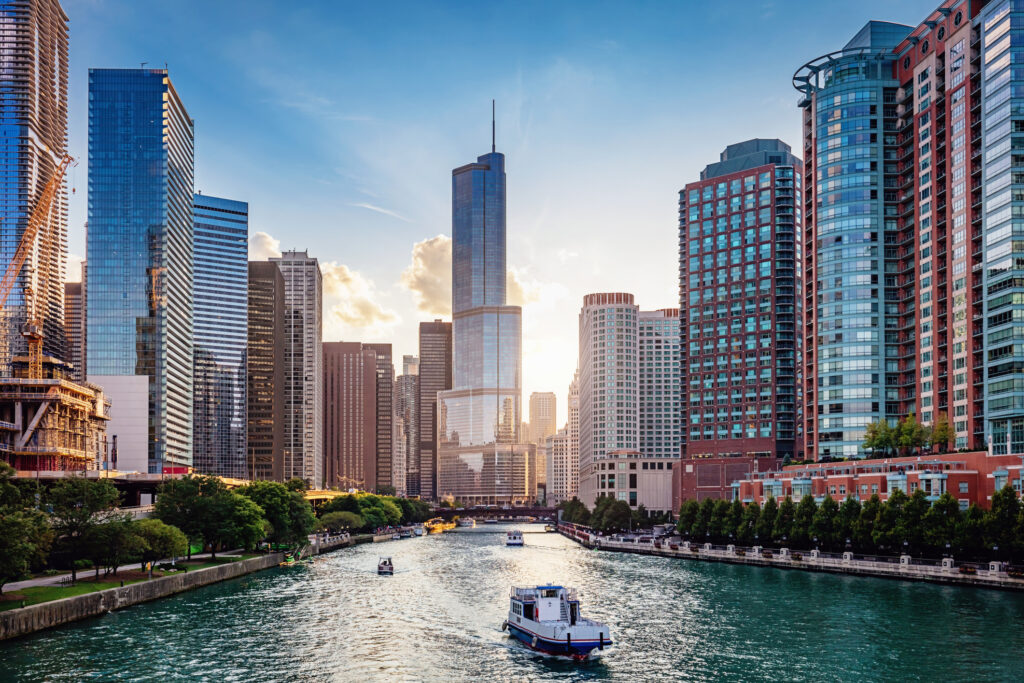 Commercial Architect: Chicago’s Remick Architecture 1 Chicago Cityscape from Chicago River Waterfront at Dusk. Small boats and tourist ferries cruising on the Chicago River towards the Michigan Lake. Chicago, Illinois, USA.