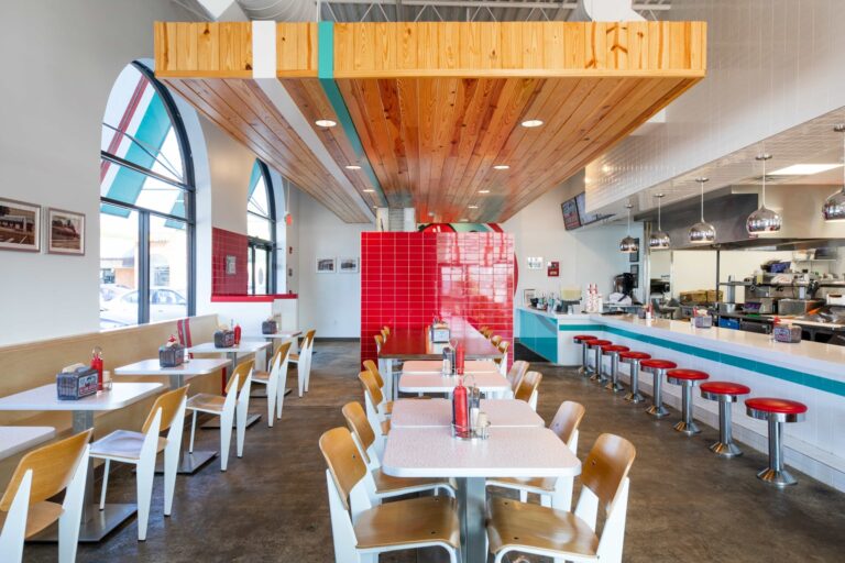 Sitting area of a burger shop with a red wall